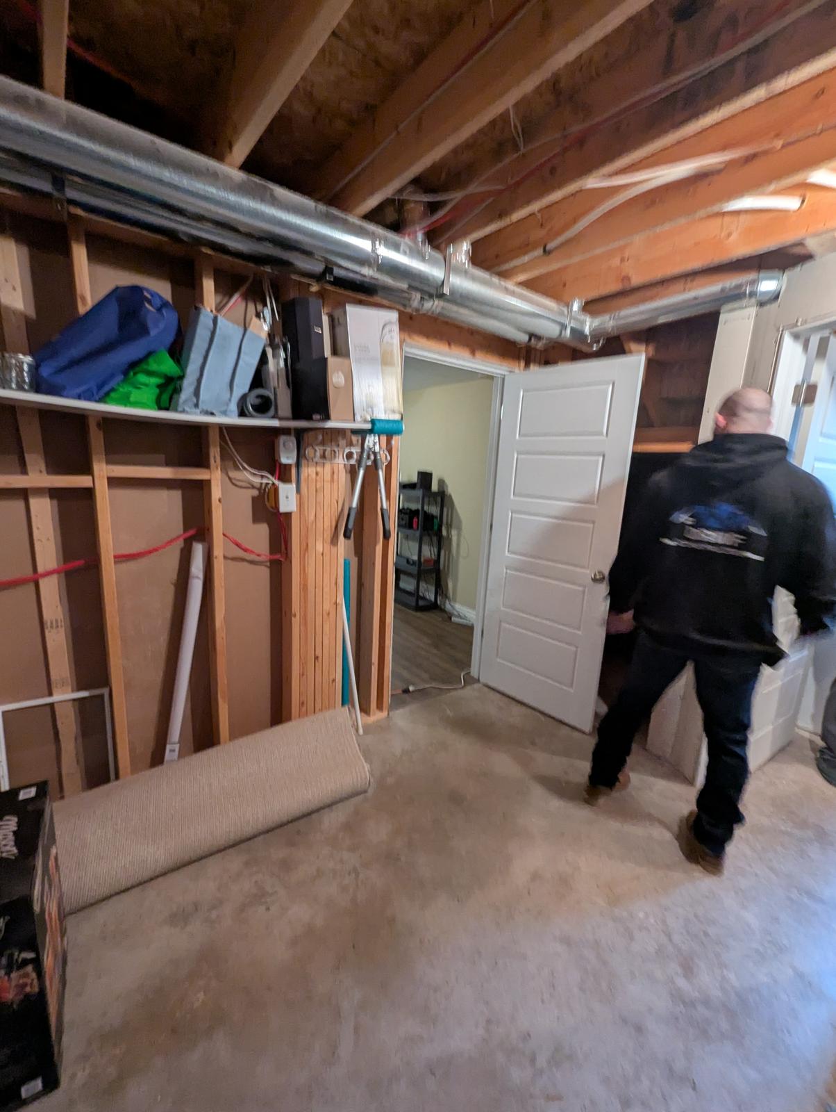 Basement before renovation with exposed ductwork and insulation, Dieppe NB