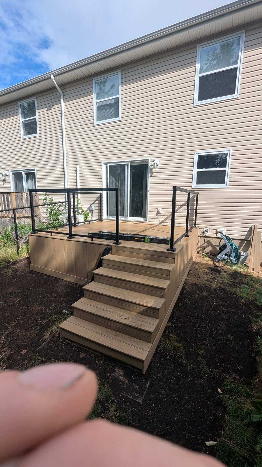 Finished composite deck with black aluminum glass-panel railing by Valhalla Construction, Chianti Street, Dieppe NB