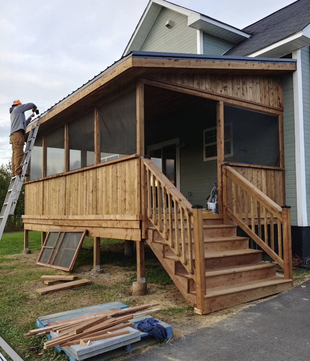 Finished covered deck with roof, railings and stairs by Valhalla Construction