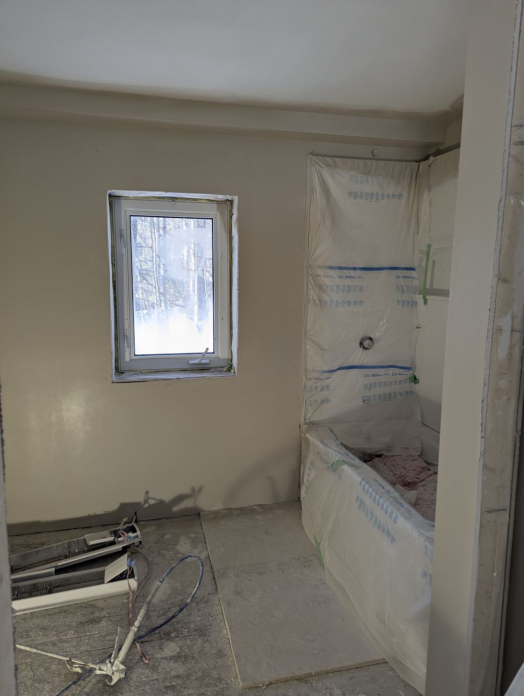 Bathroom painted with tub surround masked and tile floor going in