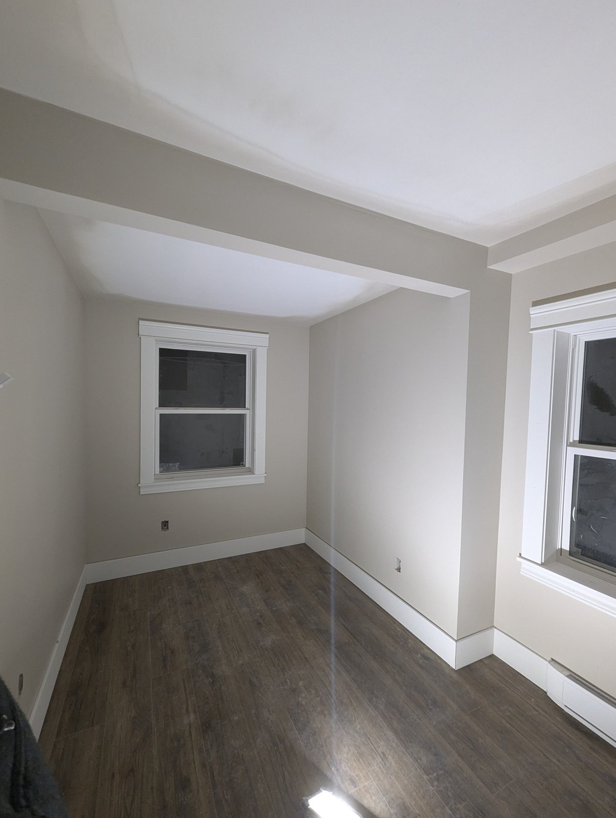 Finished bedroom with new plank flooring and trim by Valhalla Construction