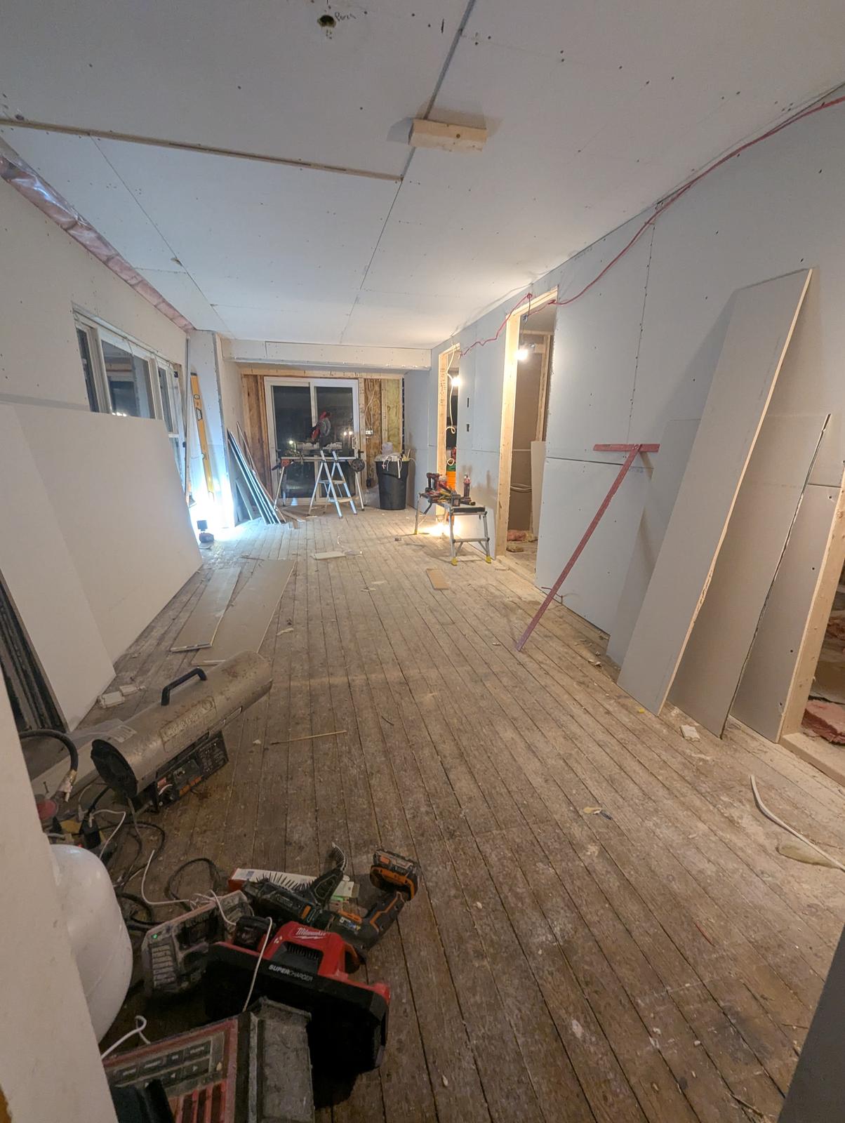 Drywall going up over new framing during a flooring and trim renovation