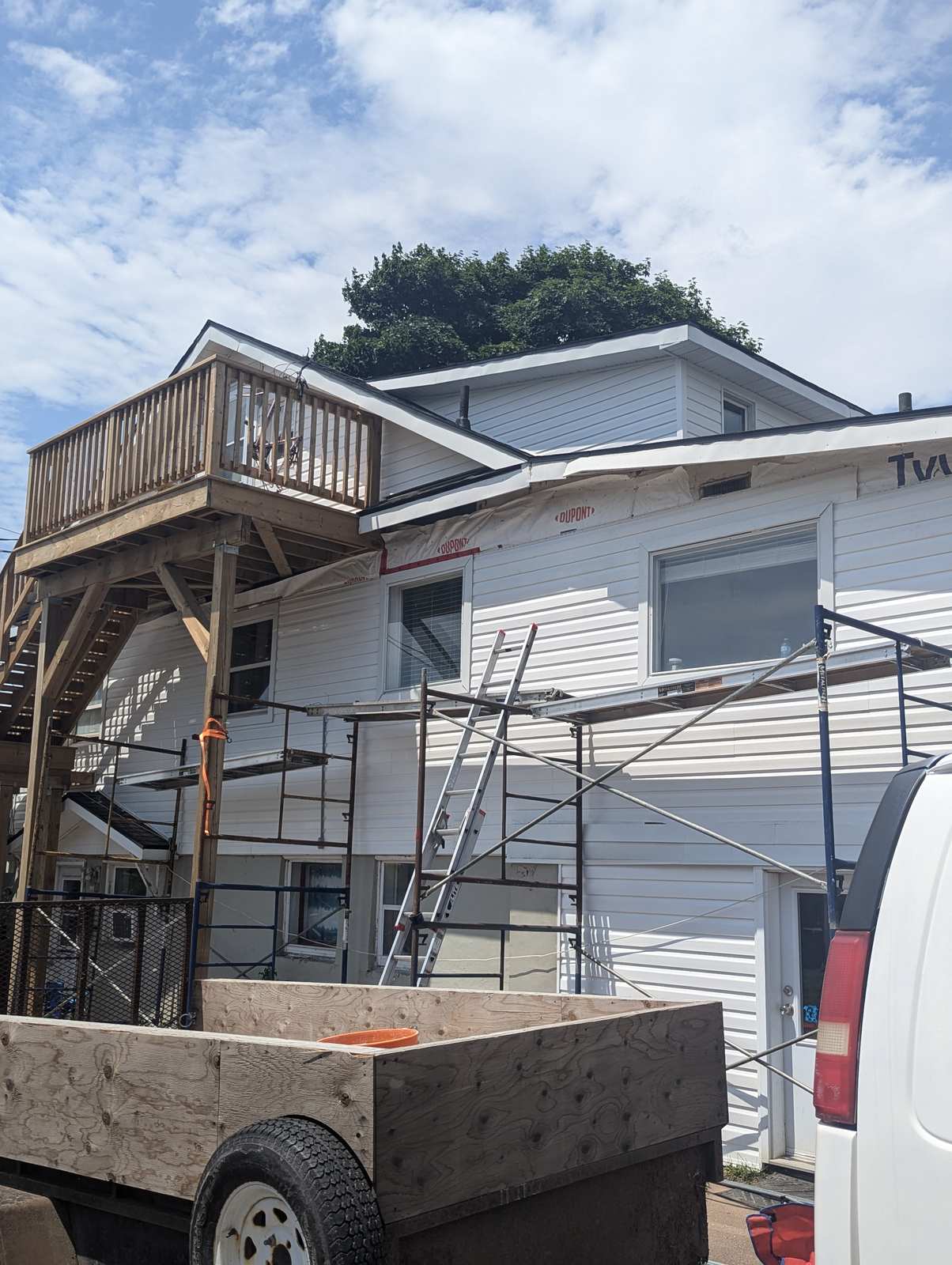 Siding installation in progress with scaffolding on a Dieppe, NB home