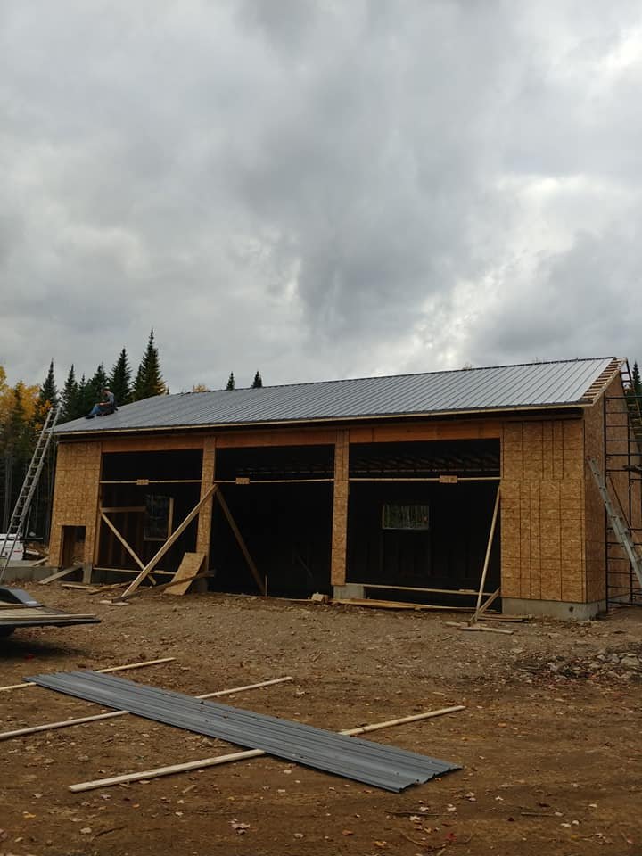 Custom garage with dark board-and-batten siding built by Valhalla Construction in Moncton, NB
