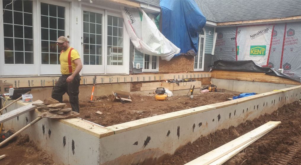 Completed and damp-proofed foundation wall with sill plate for a home addition