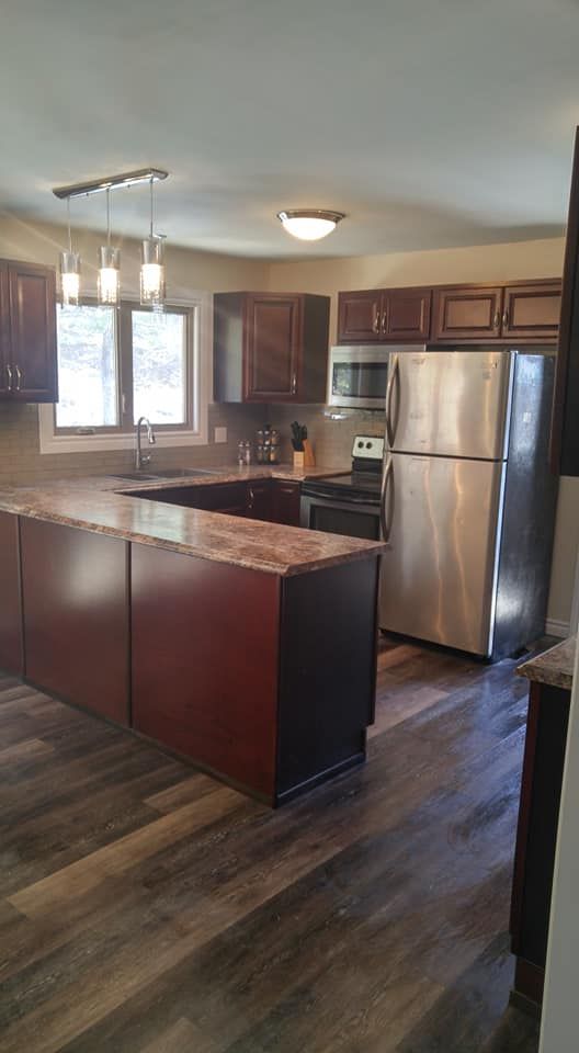 Completed kitchen renovation with granite counters, tile backsplash and pendant lighting by Valhalla Construction in Moncton, NB