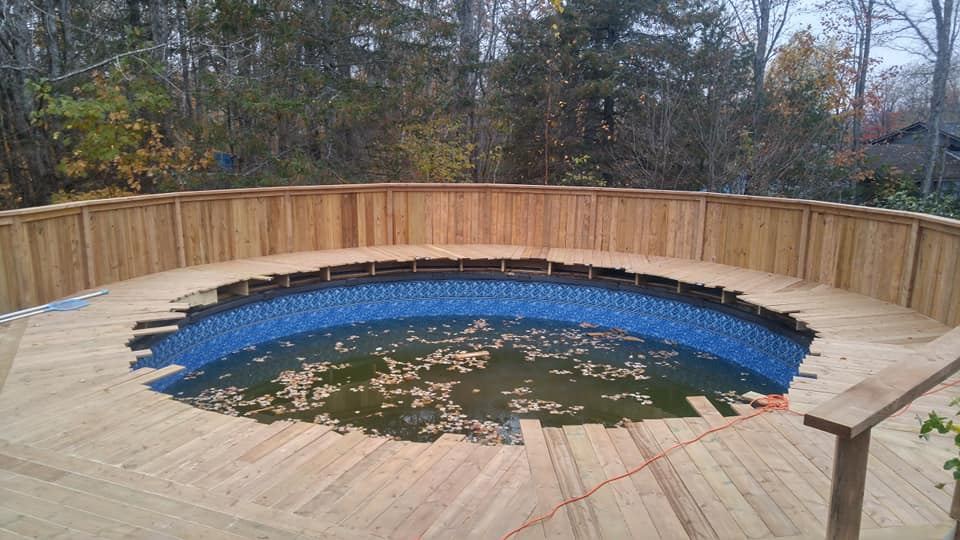 Completed wraparound pressure-treated pool deck with curved privacy surround by Valhalla Construction, Moncton NB