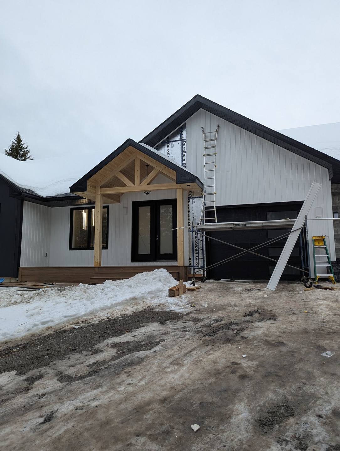 Home with premium board-and-batten siding and stone accents by Valhalla Construction in Moncton, NB, shown at dusk