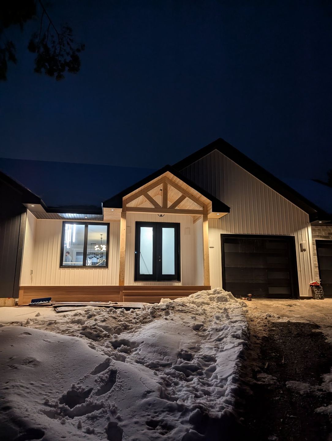 Home with premium board-and-batten siding and stone accents by Valhalla Construction in Moncton, NB, shown at dusk